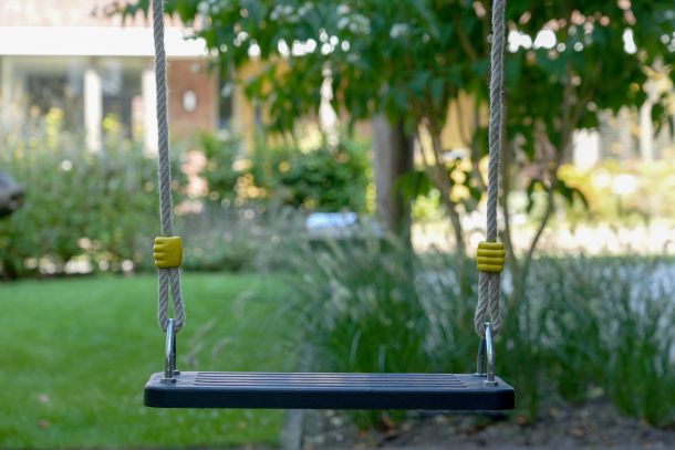 Schommel in groengrijke tuin